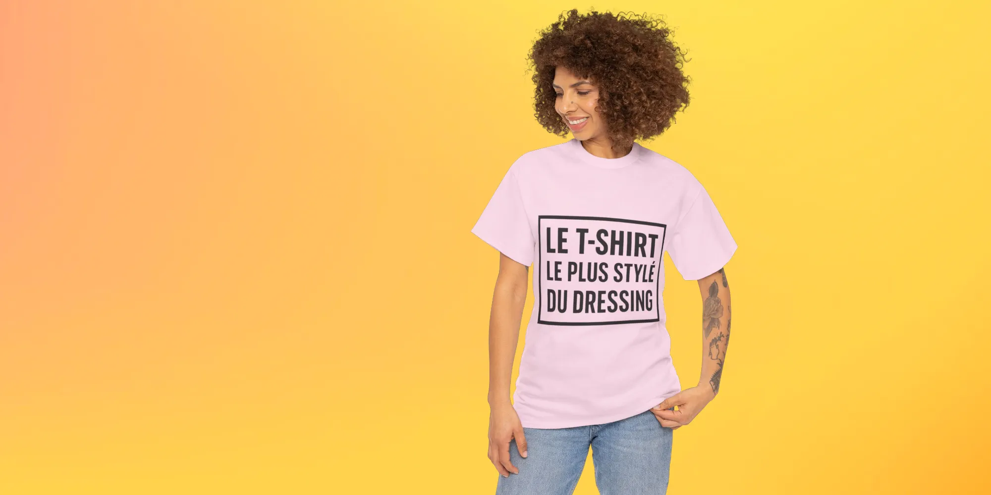 Femme souriante portant un t-shirt rose avec l'inscription 'LE T-SHIRT LE PLUS STYLE DU DRESSING' sur un fond dégradé jaune.