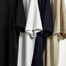 Gamme de T-shirts minimalistes dans des couleurs variées : noir, blanc, navy et beige.