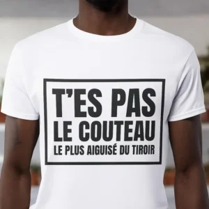 Un homme portant un T-shirt blanc avec le texte "T'ES PAS LE COUTEAU LE PLUS AIGUISE DU TIROIR" en noir.